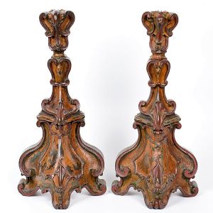 Elegante <b>par de tocheiros de encostar</b>, de época e estilo D. João V, em madeira entalhada e policromada com elementos do estilo. Base projetada ao centro. Pés triplos. Séc. XVIII. Alt. 54 cm