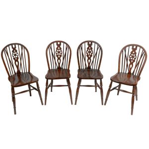 <b>Conjunto de 4 cadeiras </b>em madeira escura, com espaldar arqueado e elementos vazados no centro. Pernas torneadas e assento levemente esculpido. Estilo country inglês / Windsor. Alt. 88 cm