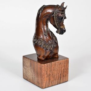 <b>VICKI KEELING - Escultura </b>em bronze patinado representando cabeça de cavalo, ornamentada com detalhes decorativos, montada sobre base em madeira. Assinada e numerada 6/24. Alt. 22 cm