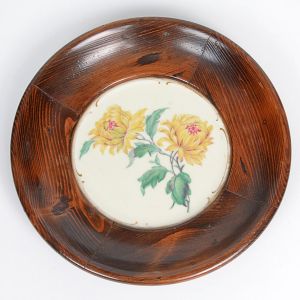 <b>Prato </b>em porcelana alemã KPM, com medalhão central decorado com crisântemos amarelos sobre fundo marfim, contornado por moldura em madeira. Apresenta numeração no verso. Diâm. 30,5 cm