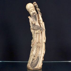 <b>Escultura chinesa </b>em marfim entalhado, representando sábio ancião com bastão e ave nos braços, com vestes e feições ricamente esculpidas. Base com selo na parte inferior. Alt. 50 cm