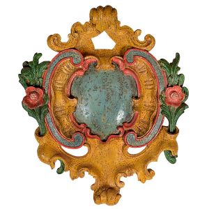 Belo <b>florão </b>barroco em madeira entalhada e vazada com elementos "rocailles" ladeados por flores e folhas. Elaborada pátina em azul, ocre, verde e vermelho. Séc. XVIII. Compr. 80 cm