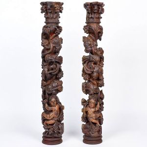 <b>Par de pequenas </b>colunas barrocas em madeira profusamente entalhada com motivos vegetais, cachos de uvas e anjos na parte inferior. Belo entalhe dos capitéis. Séc. XVIII. Alt. 73 cm