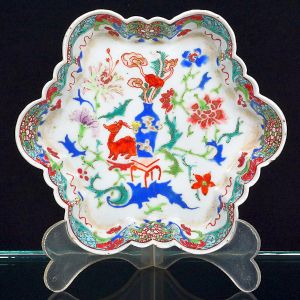 <b>Covilhete </b>em porcelana chinesa, com borda recortada em formato lobulado. Decoração policromada com reserva central figurando cervo junto a vaso de flores estilizadas. Diâm. 13,5 cm