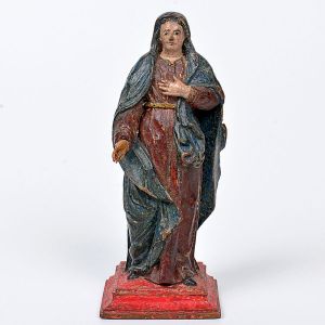 Pequena imagem de <b>Nossa Senhora das Dores </b>em madeira entalhada em policromia preservada nas tonalidades azul e vermelha. Base em "plateau" carmim. Séc. XVIII / XIX. Alt. 13,5 cm