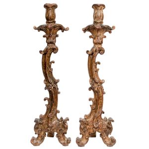 Lindo <b>par de tocheiros </b>em madeira entalhada em elegante movimento predominando elementos da rocalha com angras, volutas e acantos. Pátina original. Séc. XVIII. Alt. 72,5 cm