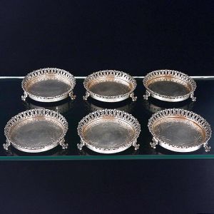 <b>Conjunto de 6 porta copos </b>em prata 833, com bordas rendilhadas. Estrutura circular com interior liso e borda vazada em motivo floral, apoiada sobre pés curvos. Diâm. 8,5 cm
