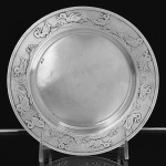 <b>Covilhete </b>em prata francesa, com centro liso e polido e borda decorada por delicado friso de aves em relevo. Contraste "Cabeça de Mercúrio" e marca de prateiro. Diâm. 17 cm