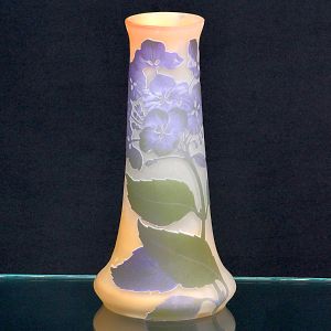 <b>Gallé</b> - Vaso em "pâte-de-verre" em camadas sobrepostas, com decoração floral em relevo nos tons lilás e verde sobre fundo opalino. Assinatura póstuma na base. Alt. 25 cm