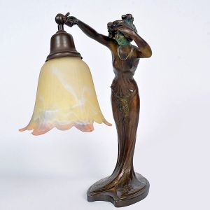 <b>Luminária </b>francesa em bronze patinado, representando figura feminina sustentando cúpula em vidro leitoso, em estilo Art Nouveau. Assinada na base L. Alliot. Alt. 38 cm