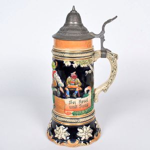 <b>Caixa de música </b>alemã, no formato de caneca, em cerâmica decorada e tampa em estanho. Marca THORENS - Switzerland, melodia "Warum ist es am Rhein so schön". Alt. 27 cm