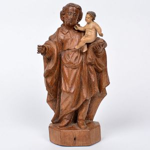 Imagem de <b>São José de Botas </b>em madeira entalhada, tendo à mão esquerda, o Menino Deus evidenciado por policromia clara. Olhos em contas. Séc. XVIII / XIX. Alt. 24 cm