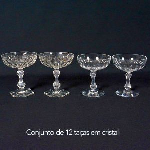 <b>Conjunto de 12 taças </b>em cristal europeu lapidado em gomos verticais composto por dois modelos similares. Um de base sextavada e outro com base circular. Alt. 11,5 cm