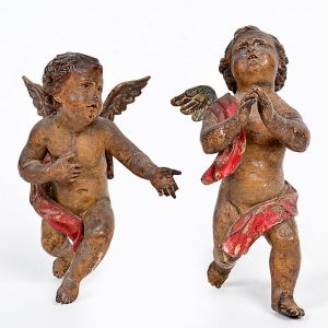 <B>Par de belos anjos de parede </B>barrocos executados em madeira entalhada e patinada em tonalidade naturalística e panejamento na cor vermelha. Séc. XVIII. Alt. 15 cm