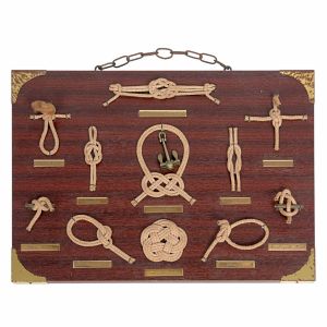 <b>Placa decorativa </b>em madeira, com diferentes tipos de nós nauticos identificados por plaquetas metálicas. Acompanha alça superior para suspensão. Med. 25,5 x 35 cm