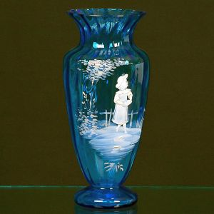 <b>Vaso </b>em cristal americano azul intenso com decoração esmaltada com figura infantil em paisagem campestre. Base circular e boca boleada. Mary Gregory. Alt. 25 cm