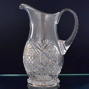 <b>Jarra </b>em cristal lapidado, bojo com rica lapidação em padrões geométricos entrelaçados, ressaltando efeitos prismáticos. Base facetada e alça espessa inteiriça.