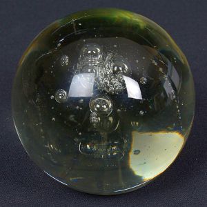 <b>Peso de papel </b>em vidro, de forma esférica, com diversas bolhas de ar internas distribuídas em diferentes tamanhos, criando efeito decorativo.Diâm. 8 cm