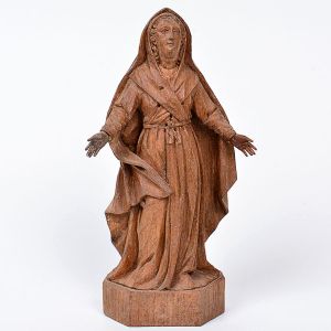Boa imagem de <b>Nossa Senhora das Dores </b>em madeira entalhada, com vestes plissadas espraiadas aos pés. Base chanfrada. Início do séc. XIX. Alt. 23 cm