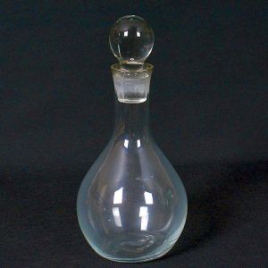 <b>Garrafa </b>em cristal incolor, com bojo em forma de gota e pescoço afilado, acompanhada de tampa esférica original com encaixe esmerilhado. Alt. 18 cm