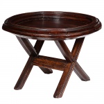 <b>Mesa de apoio </b>em madeira escurecida, com tampo circular de borda elevada e estrutura apoiada sobre base com pés em formato de "X". Med. 57 x 78 cm