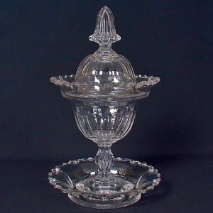 <b>Compoteira e respectivo "presentoir" </b>em cristal Baccarat lapidado. Apresenta formato de tulipa, com bojo polifacetado. Base robusta. Alt. 35 cm