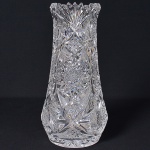 <b>Vaso </b>em cristal transparente ricamente lapidado em padrão estrelado e frisos geométricos. Bojo abaulado e borda recortada em pétalas. Alt. 32 cm