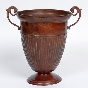 <b>Vaso </b>em bronze patinado, com corpo estriado em forma de taça sobre base circular, com duas alças laterais em volutas estilizadas. Alt. 24 cm