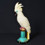 <b>Escultura em porcelana </b>alemã, Art Déco, policromada, representando cacatua sobre pedestal. No verso marca da manufatura SELB. Alt. 38,5 cm