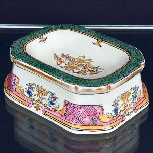 <b>Saleiro </b>em porcelana policromada de formato retangular oitavado com borda verde e friso dourado. Marca JWC 1897. Compr. 11 cm