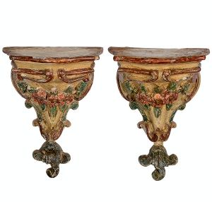 <b>Par de belas peanhas </b>policromadas em vermelho, verde e bege, com entalhes de motivos barrocos. Séc. XVIII. Alt. 33 cm