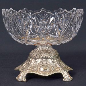 <b>Fruteira </b>em cristal lapidado sobre base em metal prateado trabalhado com relevos vegetais. Alt. 13 cm; Diâm. 15 cm