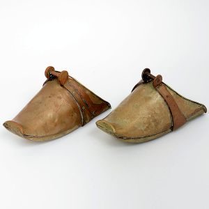 <b>Par de sapatas </b>decorativas em bronze, com acabamento patinado e detalhes laterais em metal aplicado. Compr. 25 cm