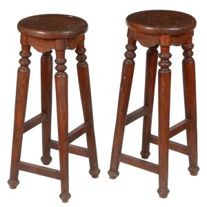 <b>Par de bancos altos </b>em madeira, com assento circular e pernas torneadas ligadas por traves retas. Alt. 75 cm