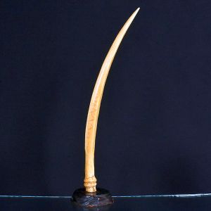 <b>Presa </b>em marfim apoiada sobre base esculpida em madeira. Alt. 59 cm