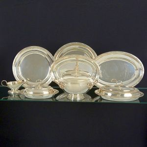 <b>Baixela </b>em metal espessurado a prata "Wolff" em excelente estado de conservação. Bordas decoradas com frisos intercalados por elemento em "X" dito "croisé". Marca do fabricante puncionada em todas as peças. Constando de sopeira circular, 2 legumeiras em dois tamanhos com alças destacáveis reversíveis em 4 travessas ovais fundas, 2 travessas circulares, 2 travessas ovais e 1 molheira. Total de 8 peças. Compr. da travessa oval maior 42 cm; Diâm. da travessa circular maior 37 cm; Compr. da sopeira 32 cm