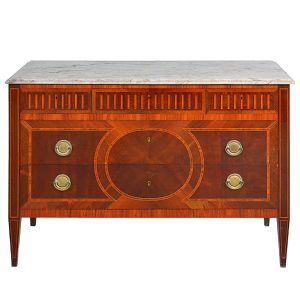 Antiga <b>cômoda</b> no estilo francês construída em madeiras nobres europeias. Caixa retangular com três gavetas dispostas lado a lado, decoradas com frisos escavados e mais dois gavetões abaixo, decorados com filetes centralizando elemento esférico. Laterais também filetadas. Pernas retas afiladas para baixo. Puxadores metálicos e tampo em mármore rajado. Apresenta selo do fabricante no verso: "Móveis Cantinho do Céu" - João Ferreira de Lima. Med. 85 x 122 x 52 cm