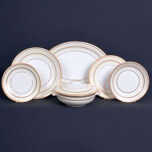 <b>Serviço de jantar </b>em porcelana francesa de Limoges, nas cores creme e branco, com arabescos filetados ouro. Marca da manufatura no verso. Constando de 31 pratos rasos (25 cm), 12 pratos fundos (23 cm), 10 pratos para sobremesa (21,5 cm), 2 sopeiras (30 cm e 28 cm), 1 molheira (17 cm), 3 travessas ovais (42 cm, 36 cm e 24 cm), 2 travessas redondas (32 cm e 29 cm), 1 saladeira funda (29 cm), 1 "bowl" (25 cm) e 3 fruteiras com pés. Total de 66 peças.