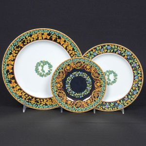 <b>Conjunto de 36 pratos </b>em porcelana Rosenthal Studio-Line, para Versace, modelo Gold Ivy. Apresentam borda com folhagens estilizadas em tons de verde, azul e amarelo, intercaladas a elementos clássicos em ouro, sobre fundo preto ou branco. Ao centro, guirlanda ornamental em policromia delicada. Marca Medusa em dourado no verso. Serviço composto por 12 pratos rasos, 12 pratos fundos e 12 pratos de sobremesa.