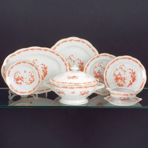 <b>Serviço de jantar </b>em porcelana polonesa "KPM". Decoração em "chinoiserie" "rouge de fer" sobre fundo branco. Constando de 24 pratos rasos (24 cm), 7 pratos de sopa, 9 pratos de sobremesa, 1 sopeira (compr. s/ as alças 32 cm), 1 legumeira redonda, 1 "bowl" redondo, 2 "bowls" quadrados, 1 travessa circular (32 cm), 4 travessas ovais (compr. da maior 38 cm), 1 covilhete oval e 1 molheira. Total de 52 peças.