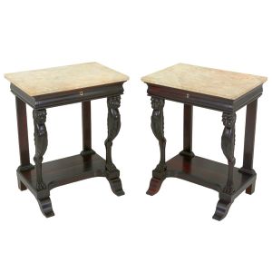 <B>Par de consoles </B>Império, retangulares, em jacarandá escurecido. Tampos em mármore de Carrara com borda boleada sobre gaveta assentada em montantes, sendo os anteriores entalhados em carrancas de leões com volutas e belas patas. Montantes posteriores em traves retas e "plateau" inferior com frente escavada. Pés ondulados. Séc. XIX. Med. 79 x 63 x 45 cm