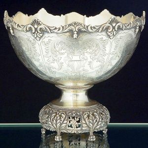 "<b>Bowl</b>" em prata portuguesa, apresentando aba sinuosa, e bojo com reservas gravadas com vasos e folhas de palma. Borda decorada com "coquilles", volutas e goivos. Base vazada com folhas de palmas e seis pés em pequenas garras. Contraste "Águia" da cidade do Porto usado a partir de 1938 e teor 833 ml. Alt. 19 cm; Diâm. 22 cm. Peso 1010 gramas.