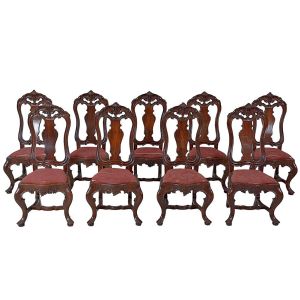 <b>Conjunto de 10 cadeiras </b>portuguesas no estilo D. José I em madeira nobre. Espaldares com tabela em recortados encimada por belos entalhes com volutas, acantos e vazados. Aba entalhada com estilizações vegetais. Pernas recurvadas unidas por travessão e terminadas em sapatas. Assentos em tecido de época desgastados. Séc. XIX. Alt. 123 cm