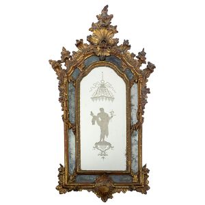 Belíssimo <B>espelho </B>europeu, provavelmente italiano, emoldurado em madeira lindamente entalhada e dourada em elementos barrocos com volutas, florões e guirlandas recamando suas laterais. Ao centro a figura de Esculápio, deus da medicina na mitologia romana, sob baldaquim. Parte inferior do florão colada. Séc. XVIII. Med. 98 x 52 cm