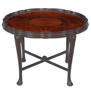 Pequena <b>mesa auxiliar </b>inglesa vitoriana em madeira nobre, apresentando forma oval com borda em ondulações e boleados. Pernas recurvadas terminadas em pés de sapatas e unidas por traves inferiores em "X". Bela "marqueterie" de tonalidade clara com guirlandas e laços circundando grande florácea. Séc. XIX. Med. 46 x 62 x 42 cm