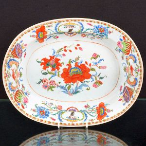 Raríssima <b>travessa </b>ovalada em porcelana Companhia das Índias pertencente ao Serviço de Madame Pompadour. Decoração em rica policromia nos esmaltes da Família Rosa, com flores e frutos, destacando-se dois pares de cartuchos, um com a figura de águia sob coroa estilizada e outro com peixes. Período Qianlong. Compr. 32,5 cm