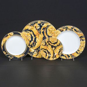 <b>Serviço de jantar </b>em porcelana Rosenthal, para Versace, modelo Vanity. Decoração barroca em preto e dourado, com profusão de volutas, folhas de acanto e elementos neoclássicos em ouro intenso sobre fundo preto. Composto por 6 pratos rasos, 6 pratos fundos e 6 pratos de sobremesa. Marcas no verso. Total de 18 peças.