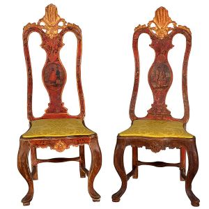<b>Par de cadeiras </b>hispano-americanas em madeira parcialmente coberta por pátina vermelha. Encosto vazado com trave central decorada com medalhão com personagens. Ao topo entalhe estilizado a ouro e detalhes floridos. Pernas recurvadas unidas por traves. Assento em tecido brocado amarelo cítrico. Séc. XVIII. Alt. 132 cm