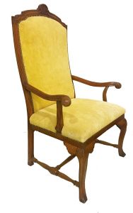 Grande <b>cadeira </b>inglesa no estilo georgiano construída em carvalho. Delicado entalhe na parte superior em composição com as cantoneiras da saia. Braços revirados para fora e terminados em bolas. Pernas levemente recurvadas unidas por travessão central torneado. Primeira metade do séc. XIX. Alt. 125 cm; Larg. 82 cm