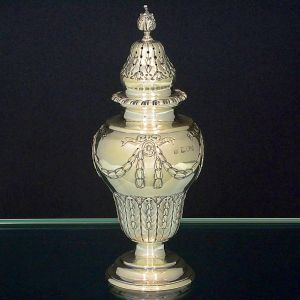 <b>Polvilhador </b>de formato balaústre em prata inglesa vitoriana decorada com guirlandas e laços. Reserva oval lisa na face anterior e parte inferior com folhas de palmas e goivos. Contraste da cidade de Londres de 1898 e vestígio de marca do prateiro CHARLES STUART HARRIS. Alt. 19,5 cm. Peso 250 gramas.